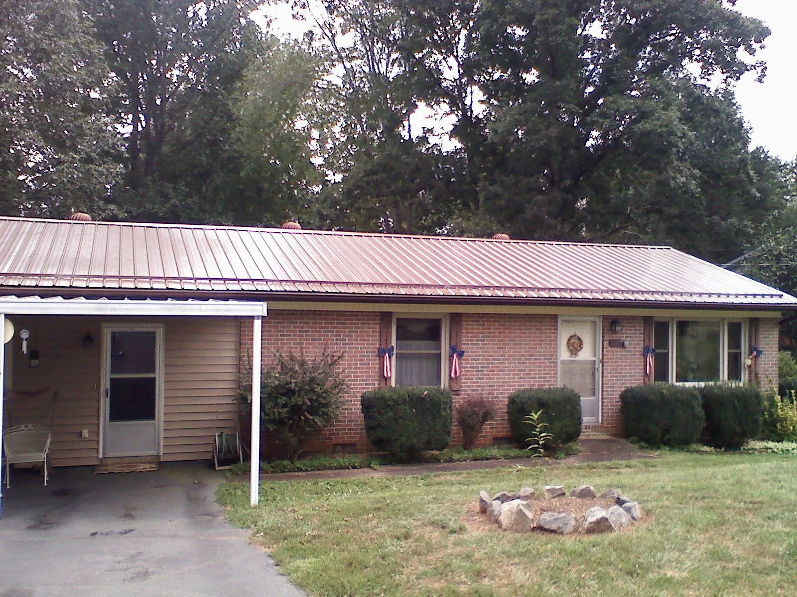 Bronze metal roof and carport on a brick ranch home — Roof Repair work by our crew in Oakhurst
